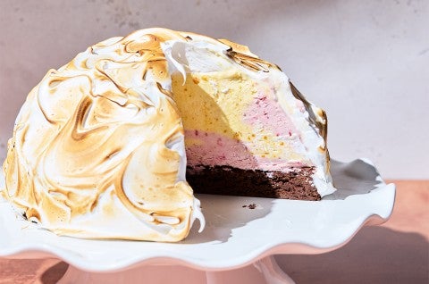 Baked Alaska on a serving tray with a piece taken out of it to show the interior - select to zoom