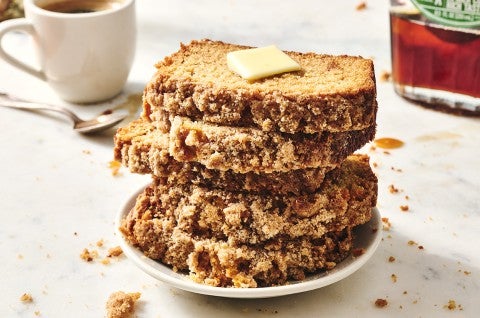 Five slices of Pancake Bread stacked on a plate showing a crumbly exterior and topped with butter. - select to zoom