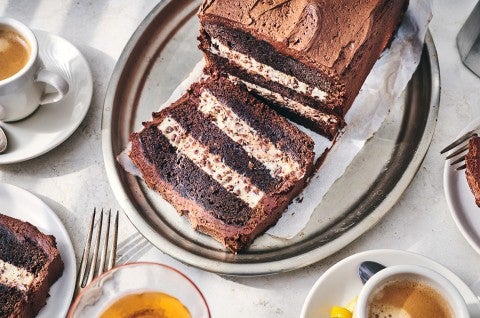 Chocolate Cassata Cake on a plate with a slice laying down showing layers of chocolate and creamy filling. - select to zoom