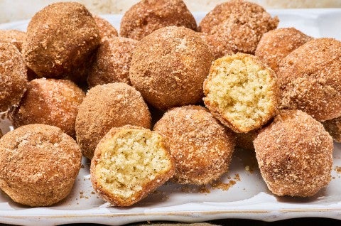 A group of Maple French Toast Mini Muffins with some broken in half to show the interior crumb.