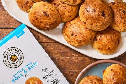 Gluten-Free Bacon Cheddar Rolls on a platter with a box of King Arthur Baking Gluten-Free Roll & Bun Mix.. - select to zoom