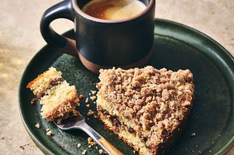 Cinnamon Streusel Coffee Cake on a dark green plate with a cup of coffee - select to zoom