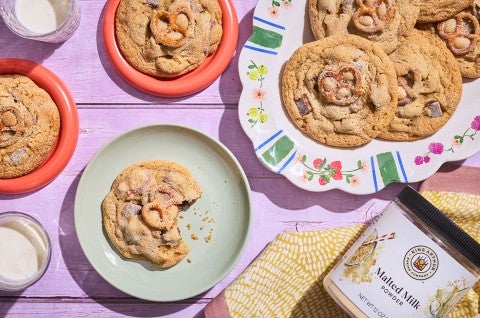 Malted Peanut Butter Chocolate Chip Cookies on plates arranged on a table, seen from above. - select to zoom