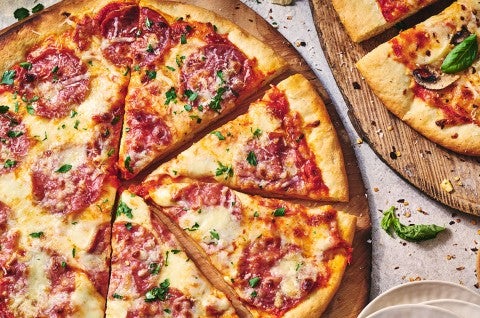 Two pizzas seen from above on wooden pizza peels