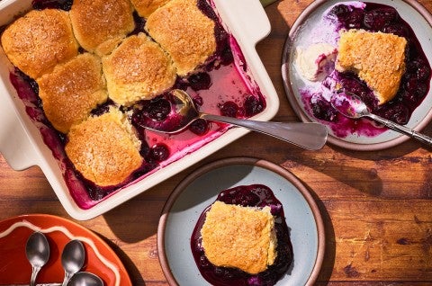 Sourdough Discard Blueberry Cobbler in a pan with slices on plates seen from above - select to zoom