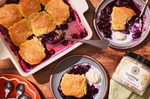 Sourdough Discard Blueberry Cobbler in a pan with slices on plates seen from above - select to zoom