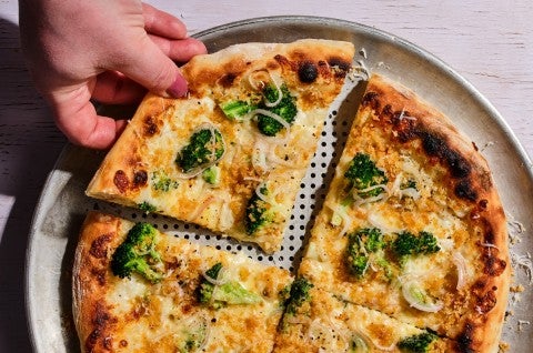 A slice of pizza with broccoli on top 