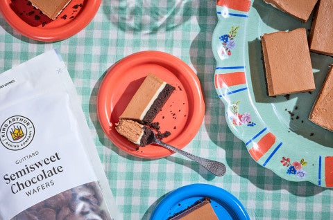 No-Bake Chocolate Cheesecake Bars on a table with a bag of Semisweet Chocolate - select to zoom