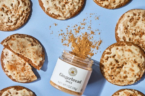 Gingerbread Latte Cookies arranged on a blue backdrop with a jar of King Arthur Baking Gingerbread spice - select to zoom