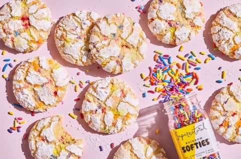 Sprinkle Crinkle Cookies on a light lavender background and a bottle of colorful sprinkle - select to zoom