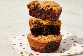 Stack of three brownie cookies on a colorful napkin. 