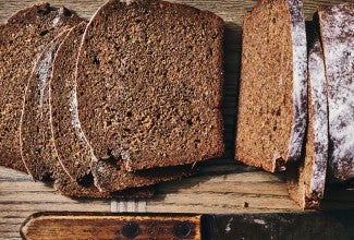 Classic Pumpernickel Bread sliced on a cutting board