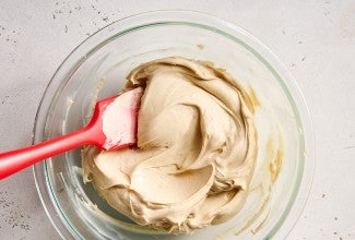 Cookie Butter Whipped Ganache being made in a clear class bowl.