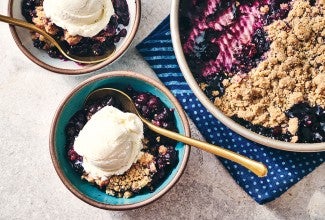 Blueberry Crisp in a round King Arthur Baking pie tin and also in a bowl topped with ice cream