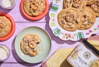 Malted Peanut Butter Chocolate Chip Cookies on plates arranged on a table, seen from above.