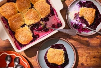 Sourdough Discard Blueberry Cobbler in a pan with slices on plates seen from above
