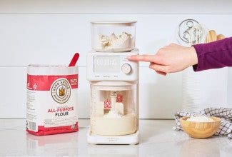 Pressing start on an automatic sourdough feeder, the Sourdough Sidekick