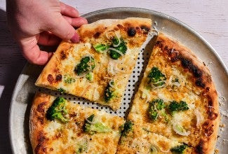 A slice of pizza with broccoli on top 