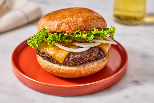 A hamburger shown with lettuce, onion, and cheese, sandwiched between a Gluten-Free Bun.