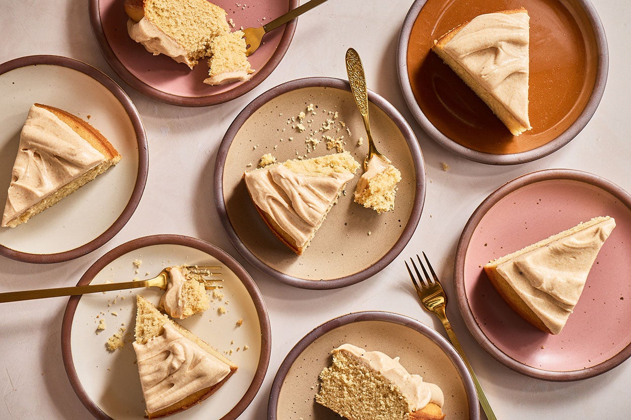 Slices of Frosted Brown Butter Cake on a variety of plates seen from above