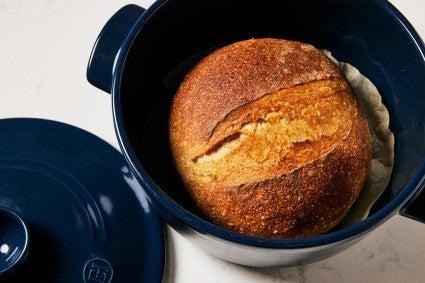 Baked loaf of bread in a Dutch oven
