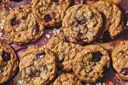 Multiple whole wheat oatmeal cookies arranged on a counter seen from above