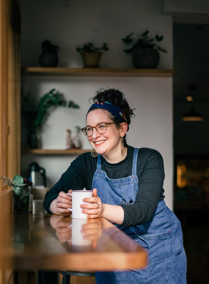 Sonya Sanford sitting with a mug in a kitchen