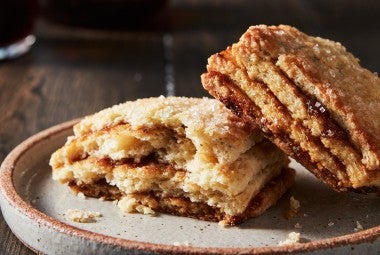 A Layered Fig Scone on a plate, broken in half, to reveal stripes of fig jam.