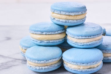 A stack of blueberry macarons on a marble countertop.